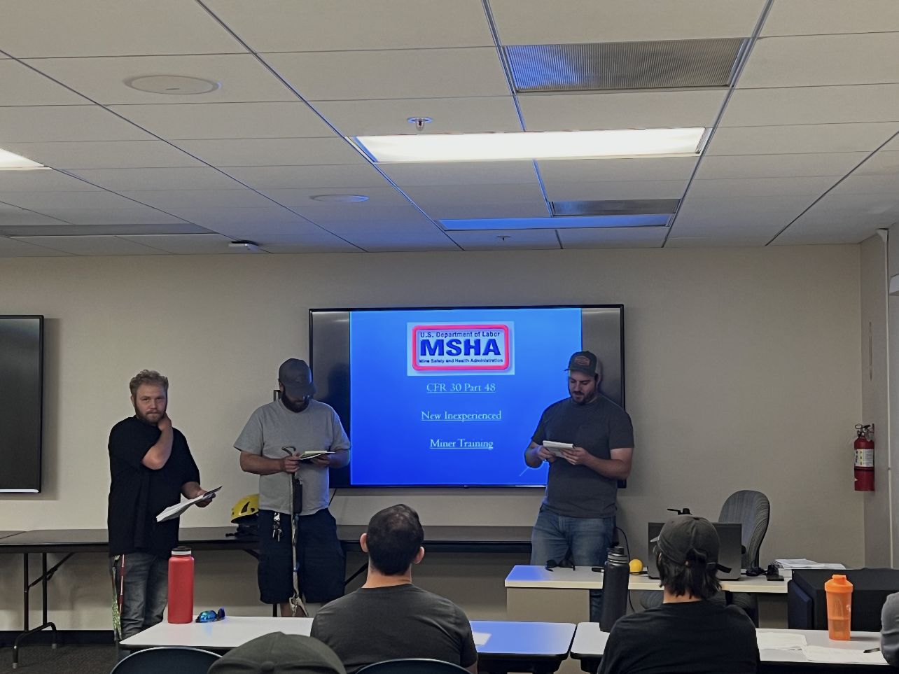 Trainees presenting in front of a CFR 30 Part 48 New Inexperienced Miner Training slide